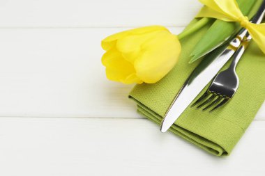 Paskalya sofrası. Beyaz ahşap arka planda lalesi olan güzel gümüş takımlar, yakın plan. Metin için boşluk