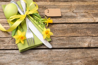 Paskalya sofrası. Güzel gümüş çatal bıçak dekoru ve ahşap arka planda boyanmış yumurta, yakın plan. Metin için boşluk