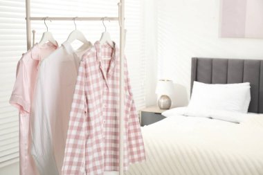İçerideki yatağın yanındaki askıda asılı duran şık pijama gömlekler, metin için yer