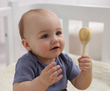 Evdeki beşiğinde ahşap çıngıraklı şirin bebek, yakın plan.