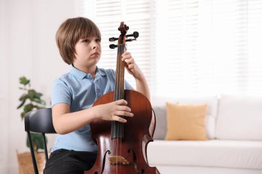 Evdeki sandalyede keman çalan küçük çocuk, mesaj için yer var.