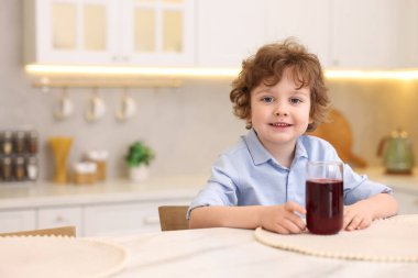 Mutfaktaki masada taze nar suyu olan küçük bir çocuk. Metin için boşluk