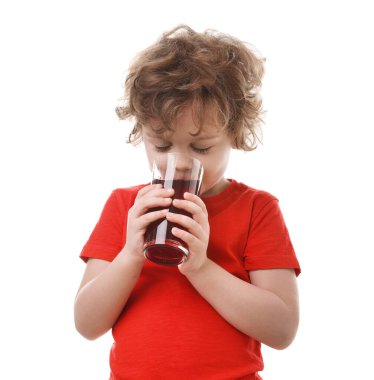 Küçük çocuk beyaz arka planda taze nar suyu içiyor.