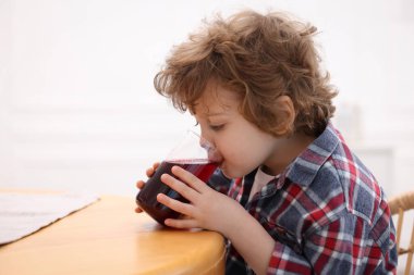 Küçük çocuk evde taze nar suyu içiyor. Metin için boşluk