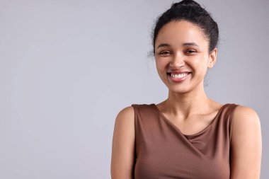 Açık gri arkaplanda güzel bir genç kadının portresi, metin için boşluk