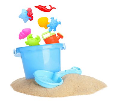 Çocuklar için plaj oyuncakları. Plastik kalıplar ve sulama kutusu beyaz zemine karşı kumda kovaya düşer.