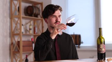 Profesyonel şarap garsonu, kırmızı şarap kadehini kapalı bir masada dolduruyor.