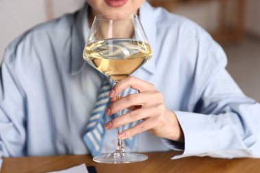 Profesyonel şarap garsonu. Beyaz şarap tadıyor. Kapalı bir masada.