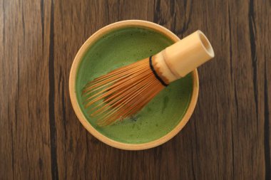 Seramik kasede taze yeşil kibrit ve ahşap masada bambu çırpıcı, yakın plan