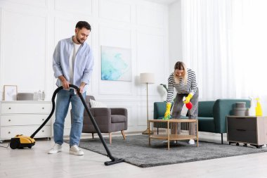 Birlikte oturma odasını toplayan bir çift. Ev işleri.