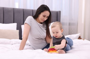 Anne, tatlı küçük bebeği ve evde yatağında oyuncağıyla