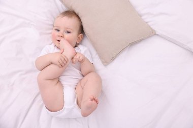 Evdeki yatakta uzanmış şirin küçük bebek, üst manzara. Metin için boşluk