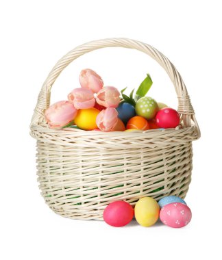 Boyanmış Paskalya yumurtaları ve hasır sepetin içindeki güzel laleler beyaza izole edilmiş.