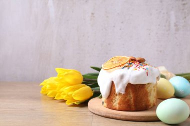 Lezzetli Paskalya pastası, laleler ve boyanmış yumurtalar gri arka planda. Metin için boşluk