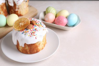 Lezzetli Paskalya pastaları ve ışık masasına boyanmış yumurtalar, yakın plan. Metin için boşluk