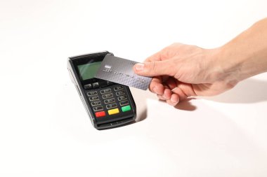 Kredi kartı olan bir adam beyaz arka planda ödeme terminalini kullanıyor.