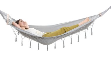 Beyaz arka planda hamakta dinlenen gülümseyen kadın.