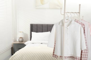 İçerideki yatağın yanındaki askıda asılı şık pijama gömlekler, yakın plan. Metin için boşluk