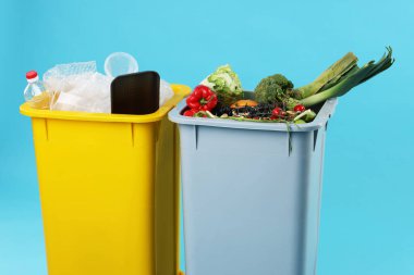 Çöpler açık mavi arka planda çöp kutularında, yakın plan. Atık sıralama