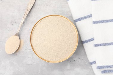Kasede kuru maya, gri masada kaşık, üst manzara.