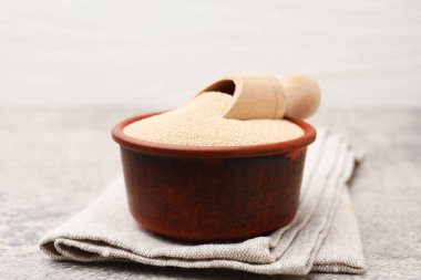 Kuru maya ve kapta kepçeyle gri masada yakın plan.