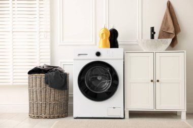 Çamaşır sepetinde çamaşır makinesinin yanında kirli çamaşırlar.