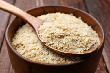 Kuru maya taneleri kasede ve kaşık tahta masada, yakın plan.