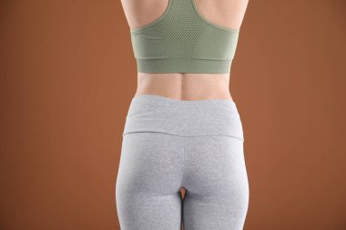 Kahverengi arka planda spor giyinen kadın, arka plan