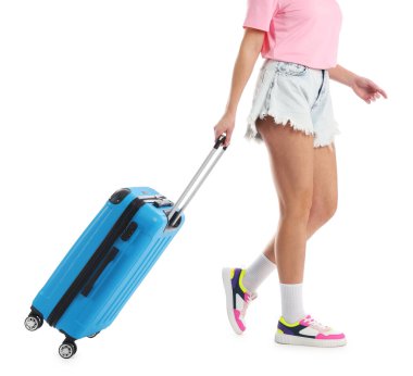 Beyaz arka planda valizi olan genç bir kadın, yakın plan.