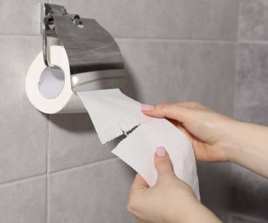 Banyoda, portre rulo yuvasını tuvalet kağıdı alarak kadın