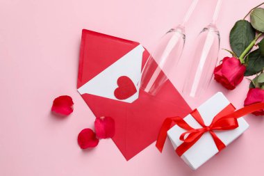 Sevgililer Günü. Zarfta aşk mektubu, kırmızı kalp, hediye, pembe arka planda gözlük ve güller, düz uzanma