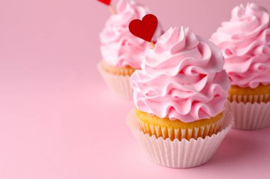 Sevgililer Günün kutlu olsun. Pembe arka planda krem şantili lezzetli kekler, yakın plan. Metin için boşluk