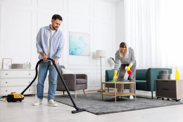 Birlikte oturma odasını toplayan bir çift. Ev işleri.