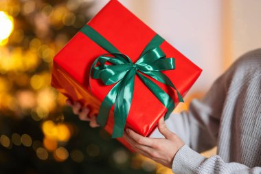 Bulanık ışıklara karşı Noel hediyesi olan adam, yakın plan.