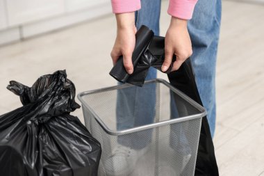 Mutfakta çöp poşetini değiştiren kadın, yakın çekim.