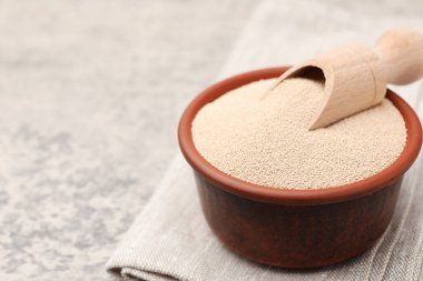 Kuru maya ve kepçeyle gri masada yakın plan. Metin için boşluk