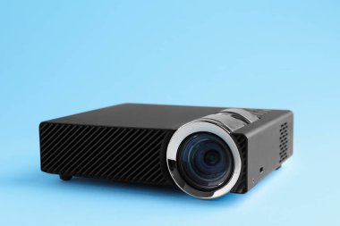 Açık mavi arkaplanda bir modern video projektörü, yakın plan
