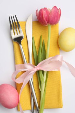 Paskalya kutlaması. Çiçek dekoru ve beyaza izole edilmiş boyanmış yumurtalar, üst manzara.