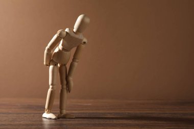 Masada koyu bej arka plana karşı bir ahşap manken, metin için boşluk