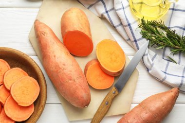 Çiğ patates, bıçak ve biberiye beyaz ahşap masa, düz yatıyordu.