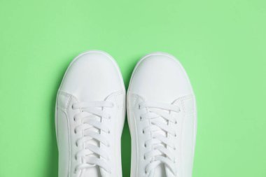 Yeşil arka planda bir çift şık spor ayakkabı, üst görünüm