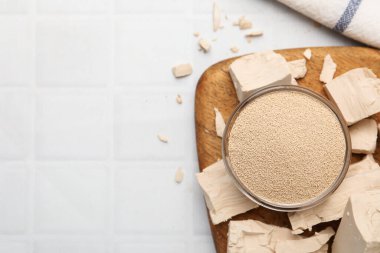 Beyaz fayanslı masada taze ve kuru maya, düz. Metin için boşluk