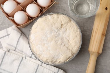 Taze hamur mantarı kasede, yumurtalarda, suda ve yuvarlak raptiyede gri masada, düz yerde.