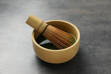 Seramik kasede taze yeşil kibrit ve gri desenli masada bambu çırpıcı, yakın plan.