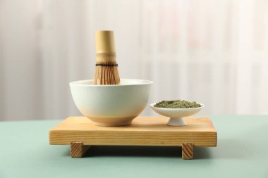 Yeşil kibrit tozu ve bambu çırpısı seramik kasede kapalı bir masada.