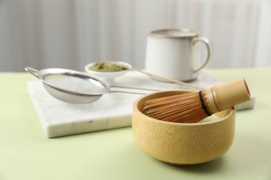 Seramik kasede taze yeşil kibrit ve yeşil masada bambu çırpıcı, yakın plan.