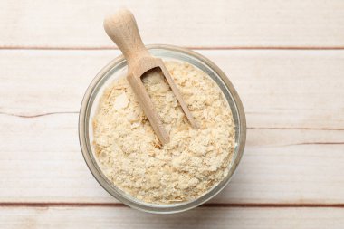 Kavanozda kuru maya taneleri ve ahşap masada kepçe, üst manzara.