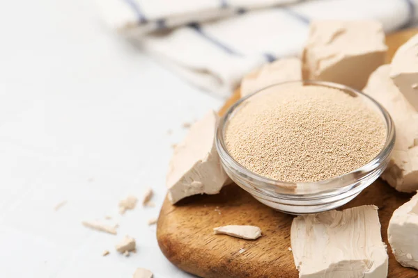 Beyaz fayanslı masada taze ve kuru maya, yakın plan. Metin için boşluk