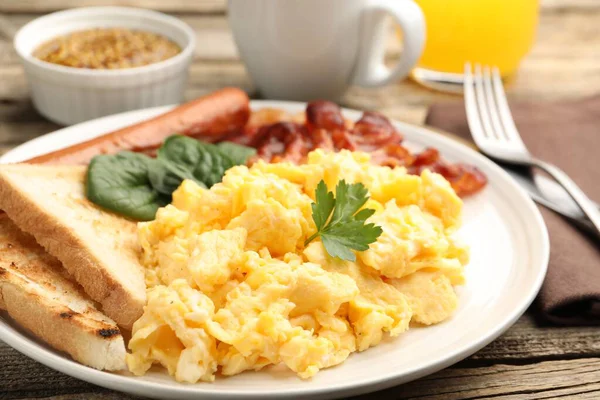 Lezzetli bir kahvaltı. Pastırmalı yumurta ve sosis. Masada servis ediliyor. Yakın plan.
