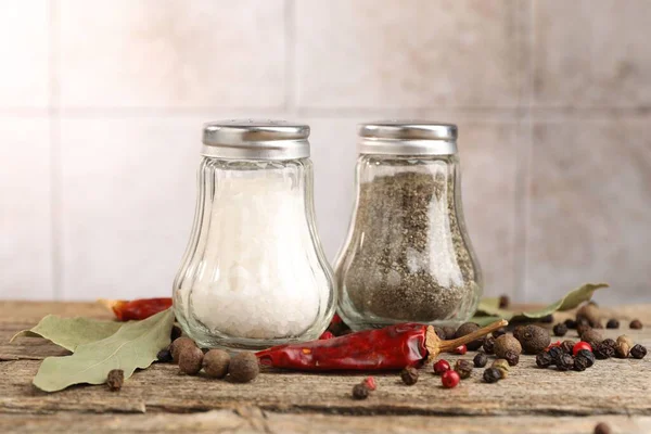 Ahşap masada baharatlı tuzluklar ve biberlikler bulanık arka planda, yakın plan